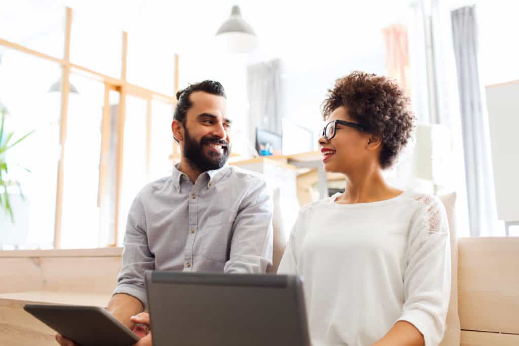 A young man and young woman smile at each other