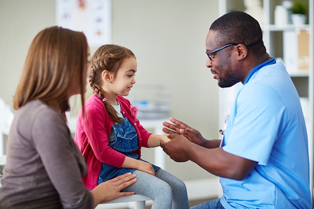 Medical professional examining little girl