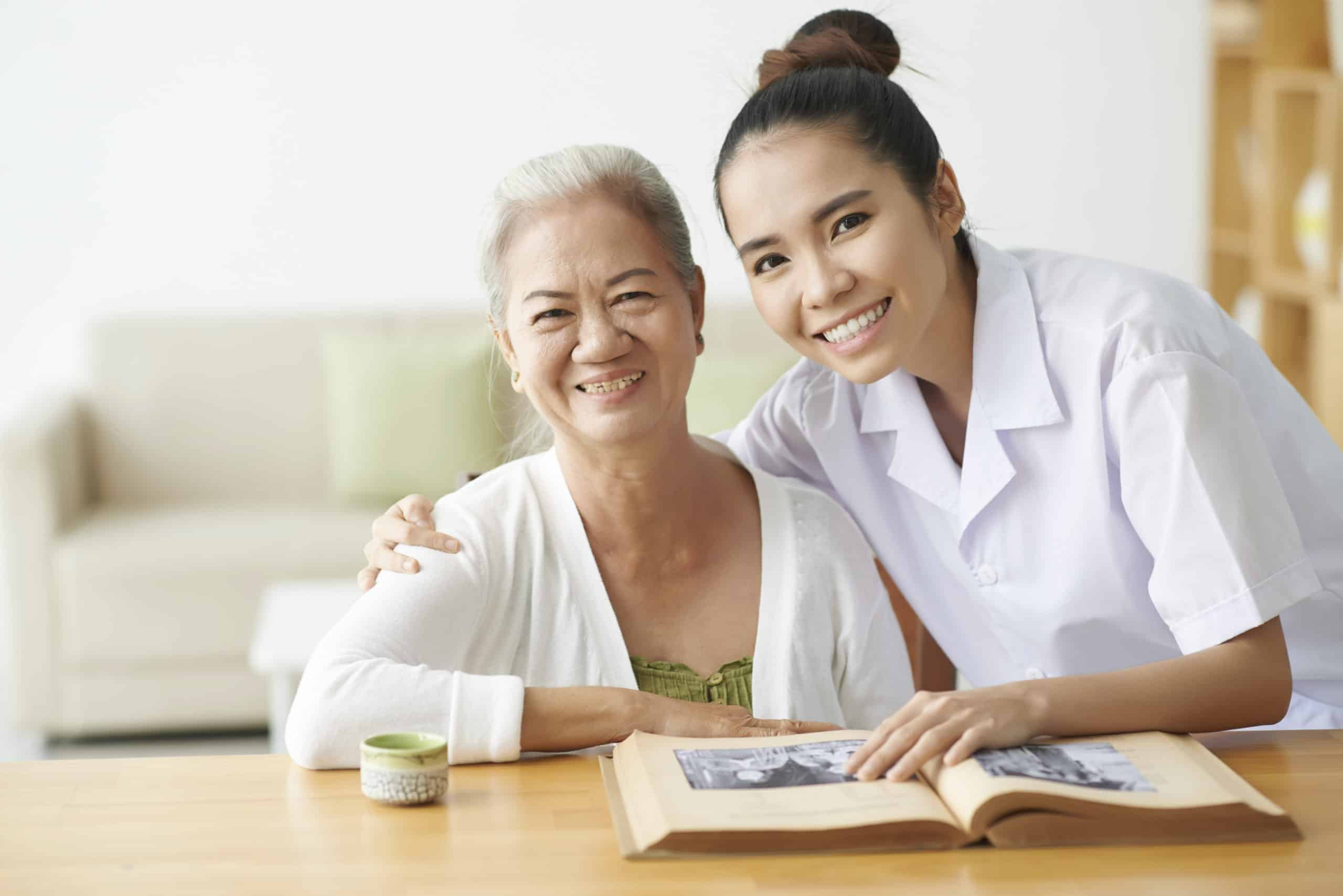 Young nurse taking care of aged female in clinic