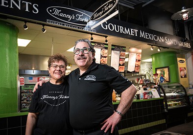 Two business owners in front of a store