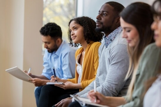 People listening and taking notes