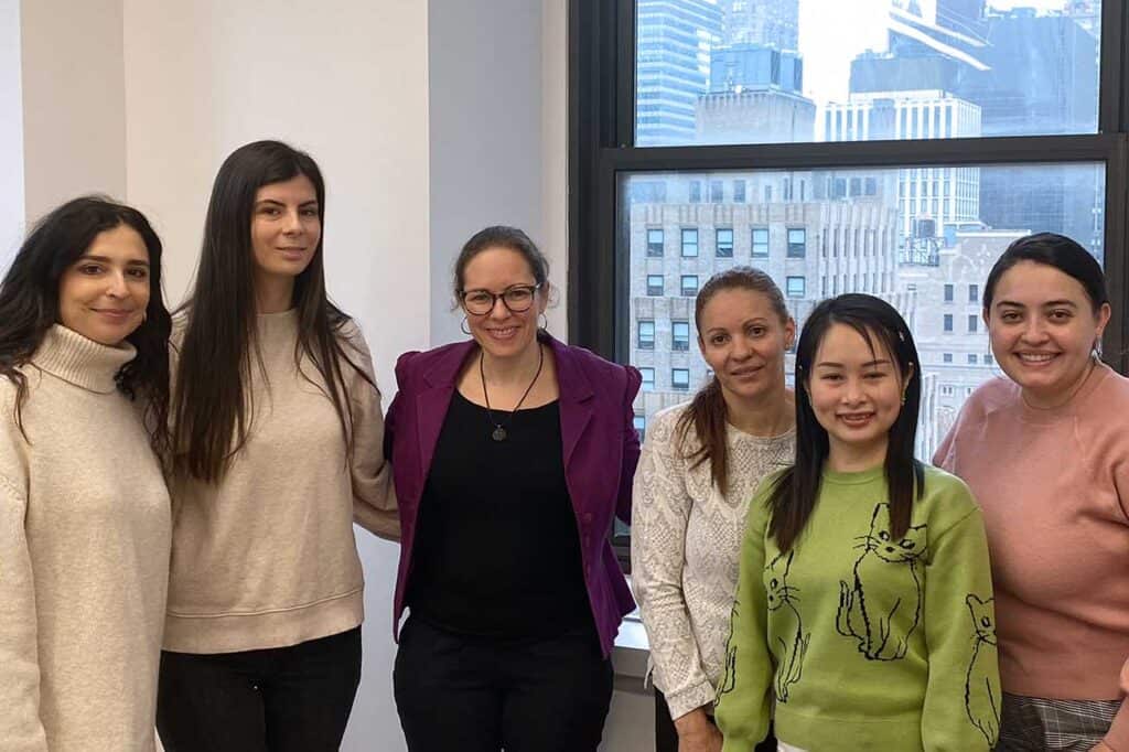 Group of office workers standing with workplace mentor.