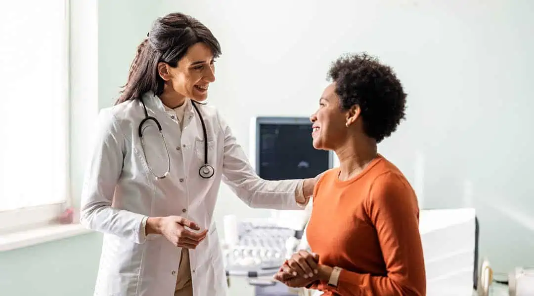 Physician and patient talking and smiling