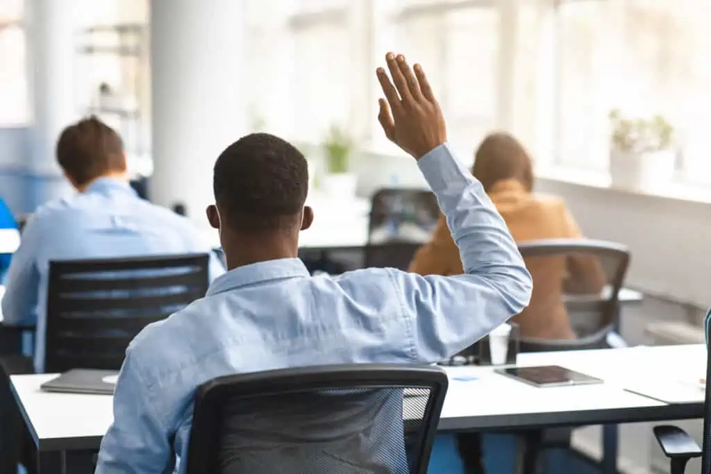 Back view of a student raising hand