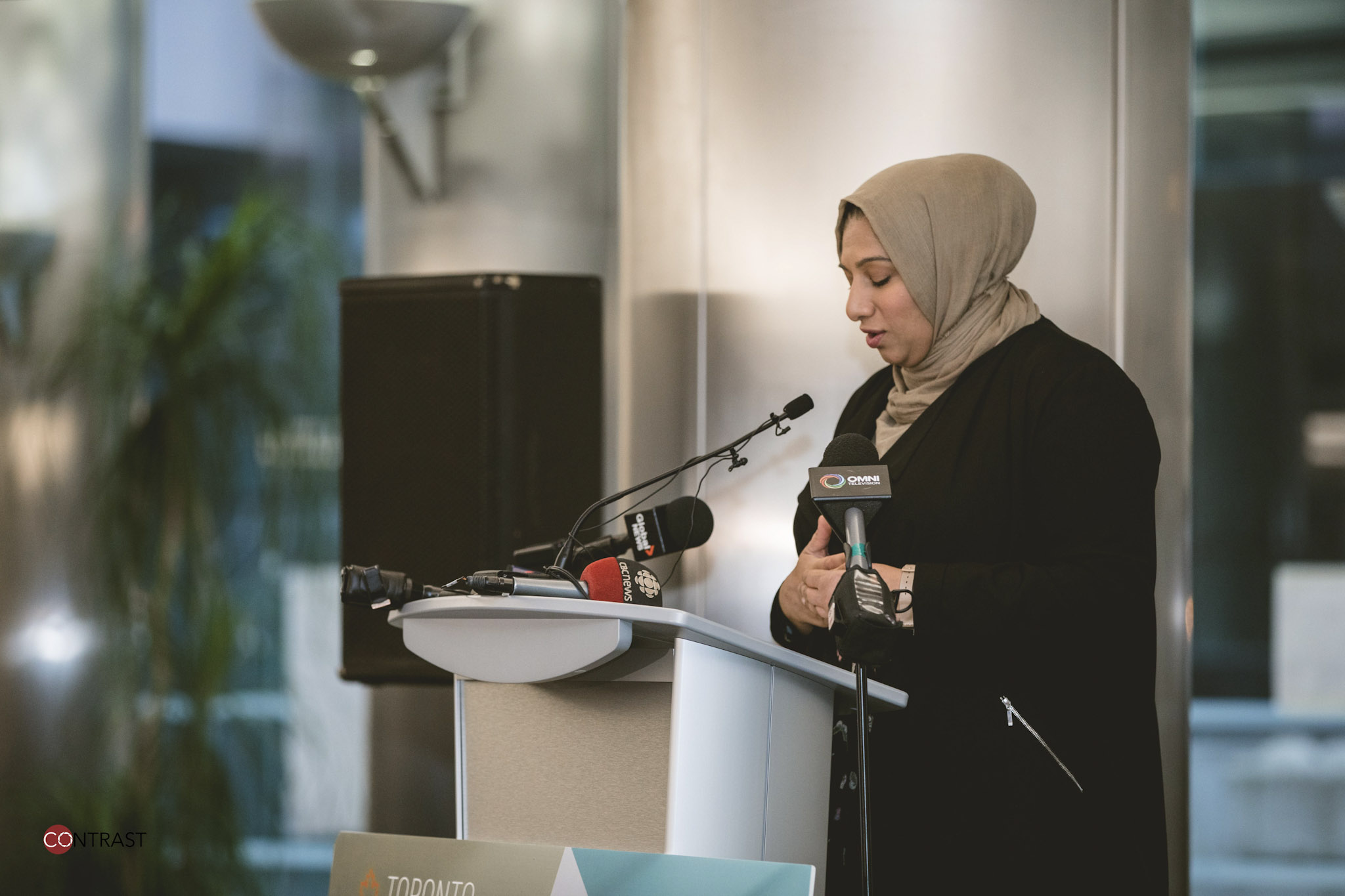  Young woman speaking from podium at Refugee Hiring Event