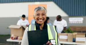 Woman, clipboard and manager in charity, volunteer and organizer for outreach program, smile and portrait. Happy senior person, non profit and support in social responsibility for NGO foundation