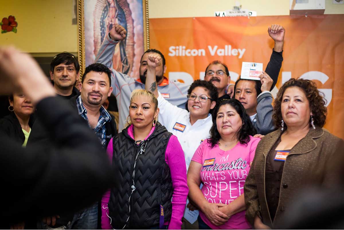 Group celebrating in front of Silicon Valley banner