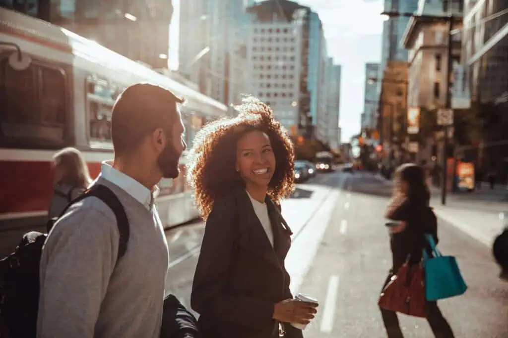 Woman crossing street and smiling at man (GTB blog hero)